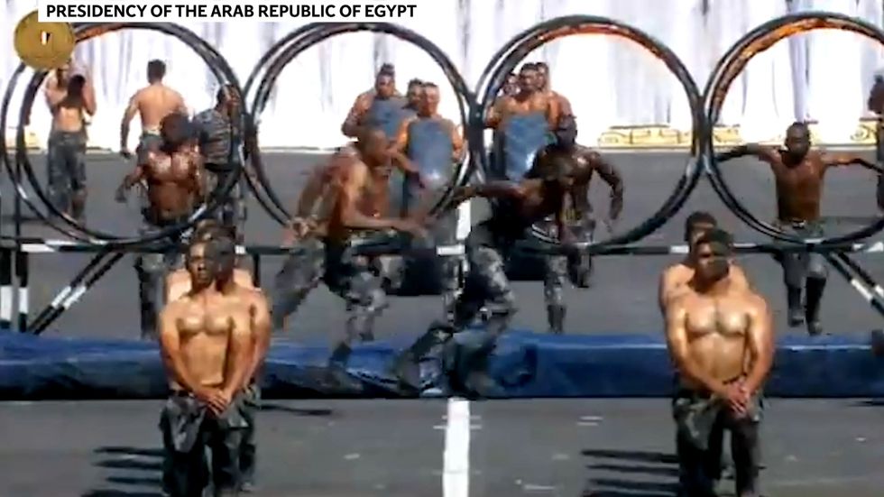 Topless Egyptian army cadets pull tanks and jump through hoops of knives in ceremony