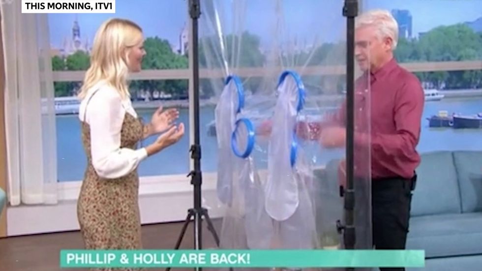 Holly Willoughby and Phillip Schofield hug through a plastic sheet on This Morning