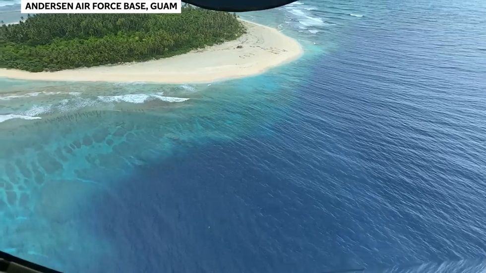Men rescued from uninhabited Pacific island after writing SOS in sand