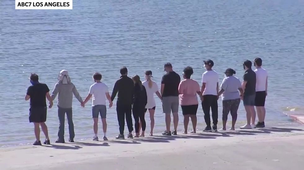 Glee cast hold hands beside the lake where Naya Rivera died