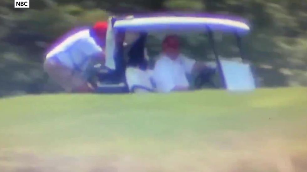 Donald Trump drives golf cart with caddie hanging off the back.mp4