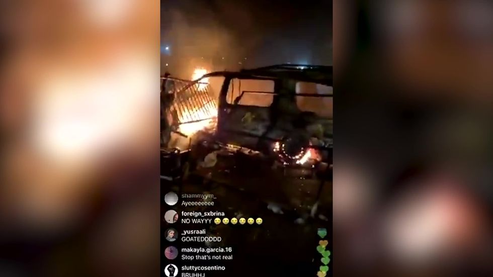 George Floyd protesters blast audio from The Purge on a loud speaker as cars and buildings burn