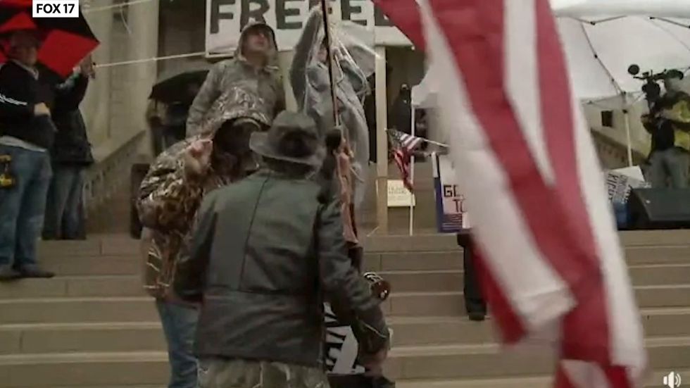 Fight break out at Michigan protest police confiscate axe