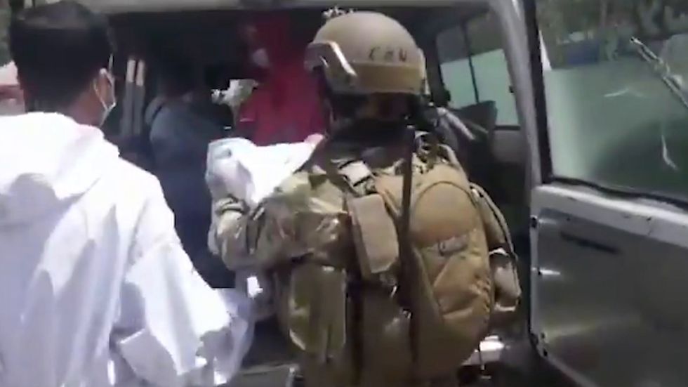 Security forces rescuing a newborn baby from Kabul hospital attack
