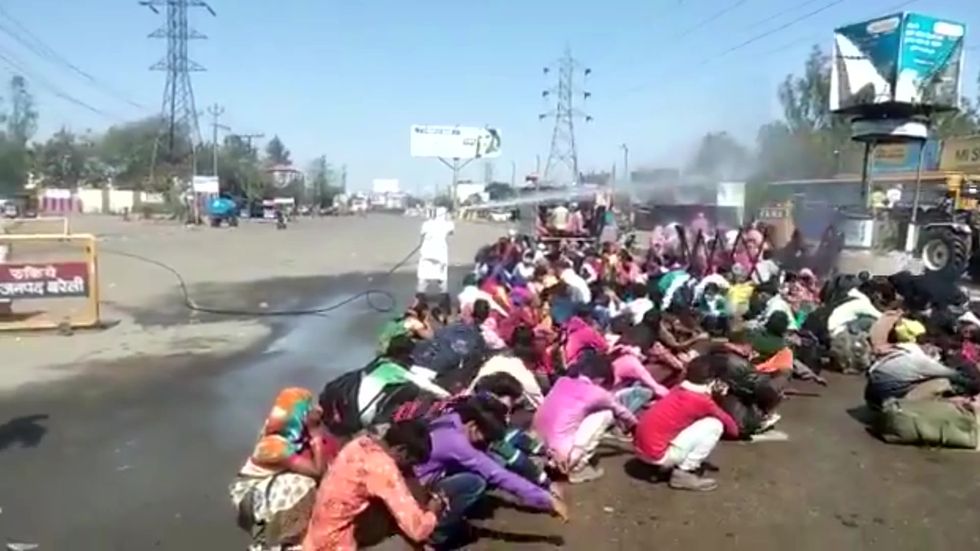 People sprayed with chemical disinfectant to try to protect against coronavirus in India