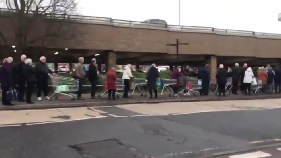Elderly people queue down the road for special shopping hour at Sainsbury's in Hoddesdon