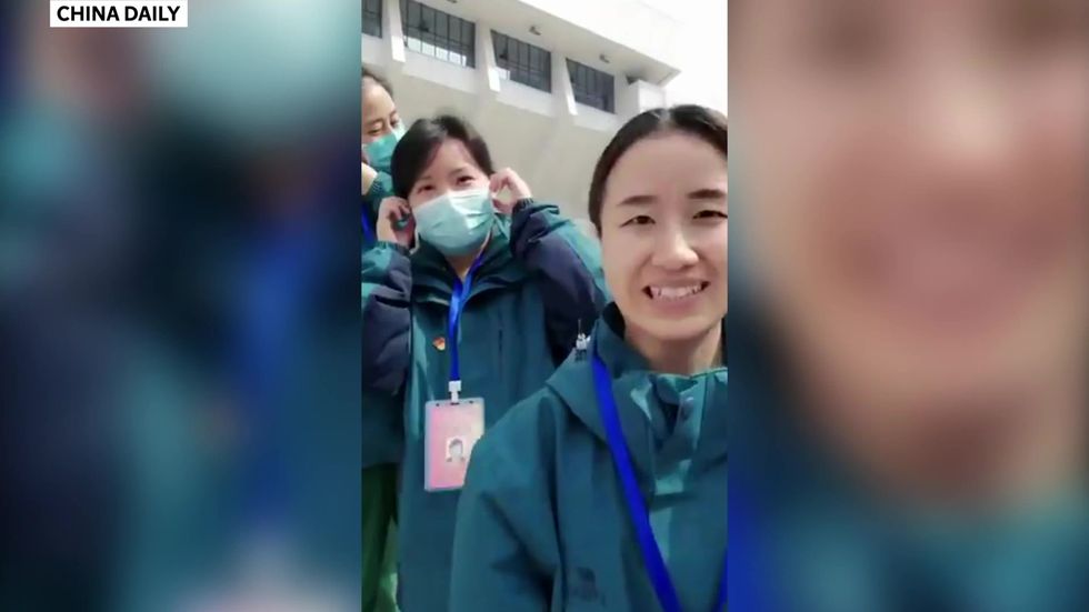 Medical teams in China smile as they remove their masks one by one