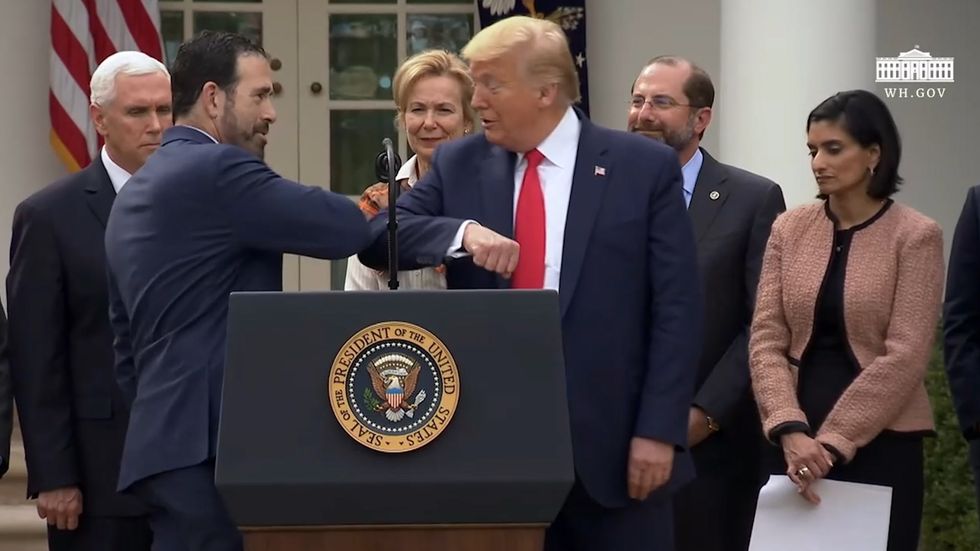 Trump bumps elbows with health care executive at coronavirus press conference
