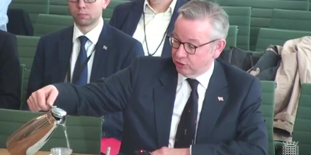 michael-gove-spills-water-on-his-phone-and-papers-indy100