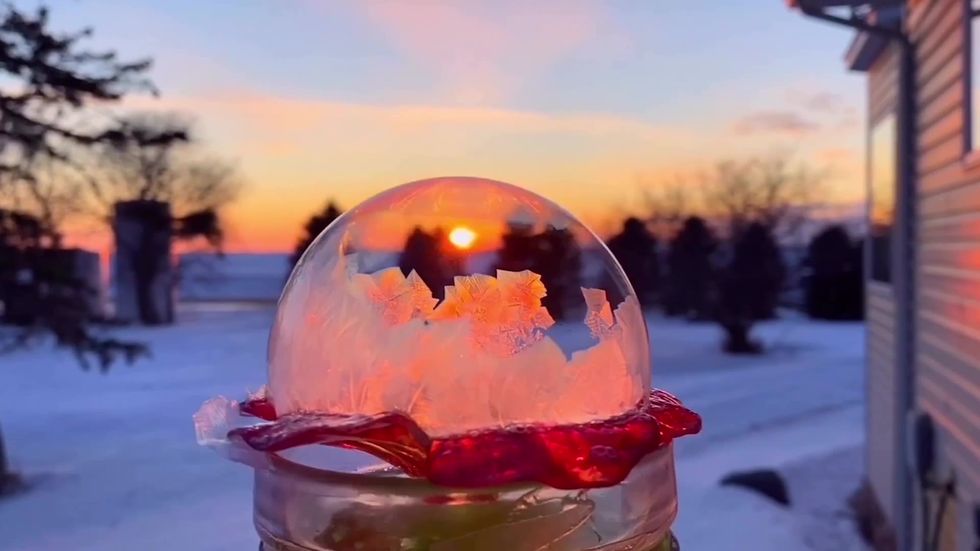 Slow motion footage captured of water ball freezing in Minnesota