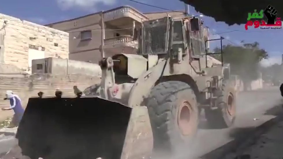 Israel security forces drive massive slabs of rock in armored bulldozer at speed towards Palestinian protesters
