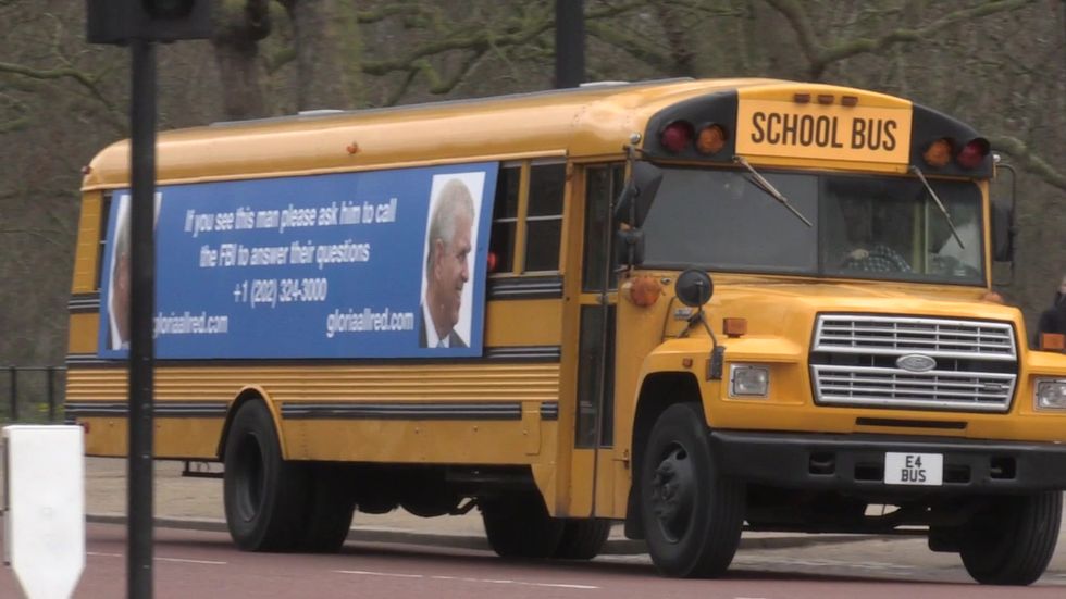 School Bus With Prince Andrew Message Drives Past Buckingham Palace