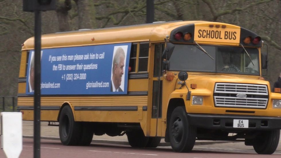 School Bus With Prince Andrew Message Drives Past Buckingham Palace