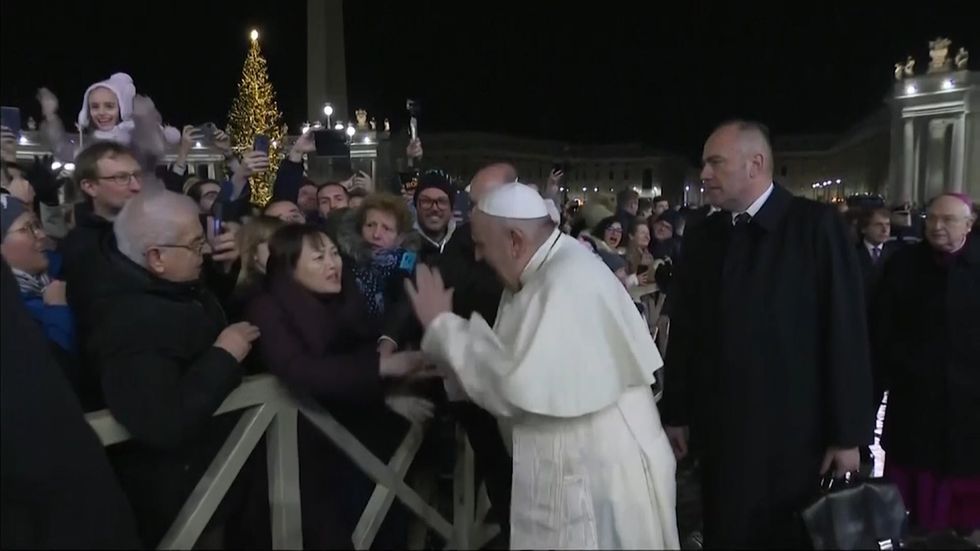 Angry Pope slaps away woman's hand as she tries to pull him in on New Year's Eve