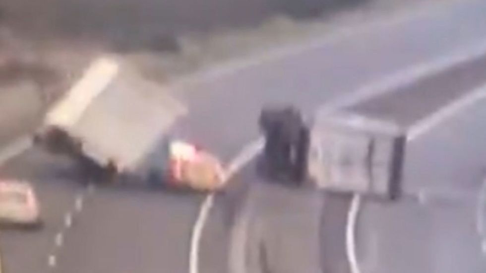 Lorry falls on to police car on motorway in strong winds