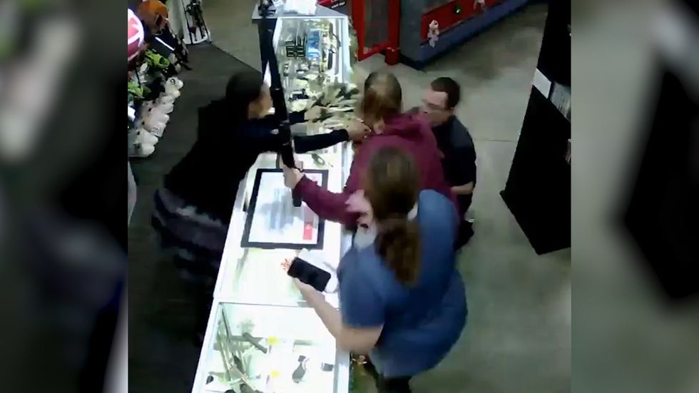 Women admiring rifle in gun store fails to notice baby falling off shop counter