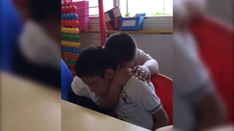 Boy with down's syndrome comforts classmate  with autism