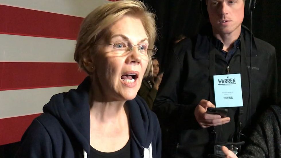 Elizabeth Warren accuses billionaire Michael Bloomberg of trying to 'buy nomination' as she fights to hold on in Iowa