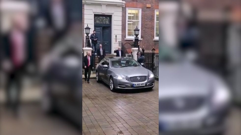 Boris Johnson waves to climate activists outside Conservative HQ but doesn't answer