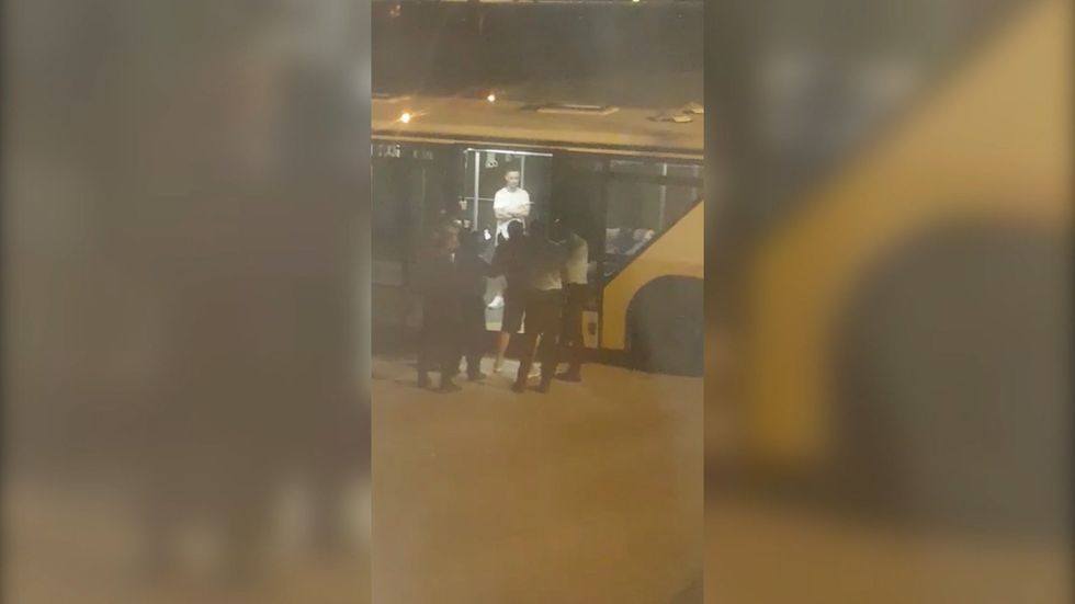 Group bundled off plane when man spits at woman