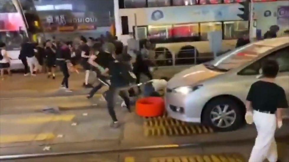 Plain-clothed police officer attacked by protesters with petrol bomb in Hong Kong