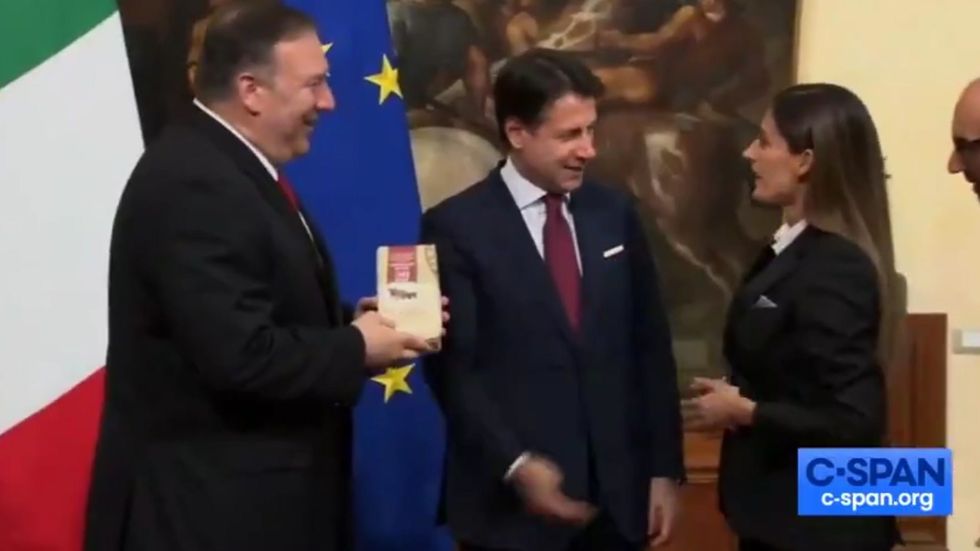 Mike Pompeo handed cheese by protester in Italy who pleads with him to end Donald Trump's trade war