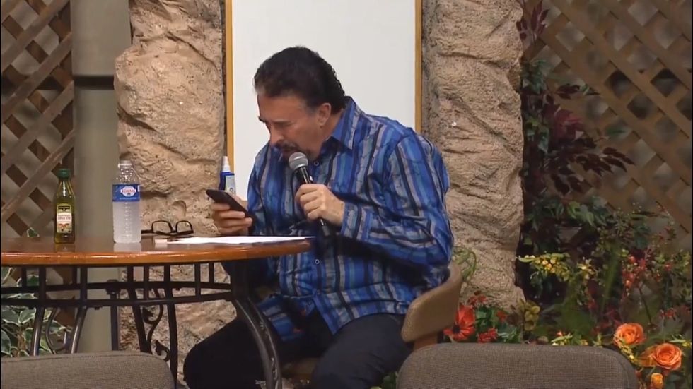 Preacher checks his phone while 'speaking in tongues'