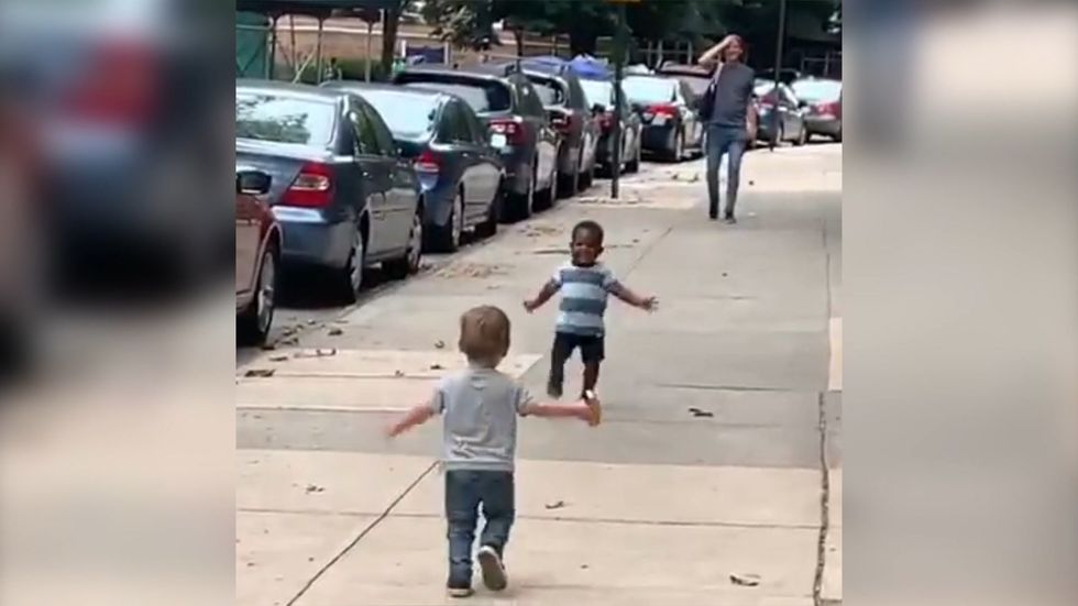 Adorable moment two toddlers run to hug each other in street