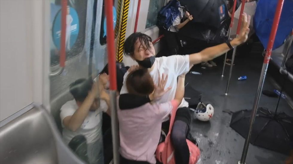 Distressing footage shows protester protecting woman as Hong Kong riot police violently storm metro 