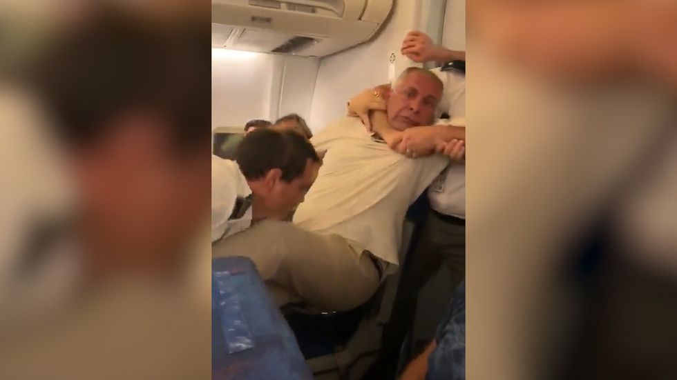 Plane security drag man from his seat 