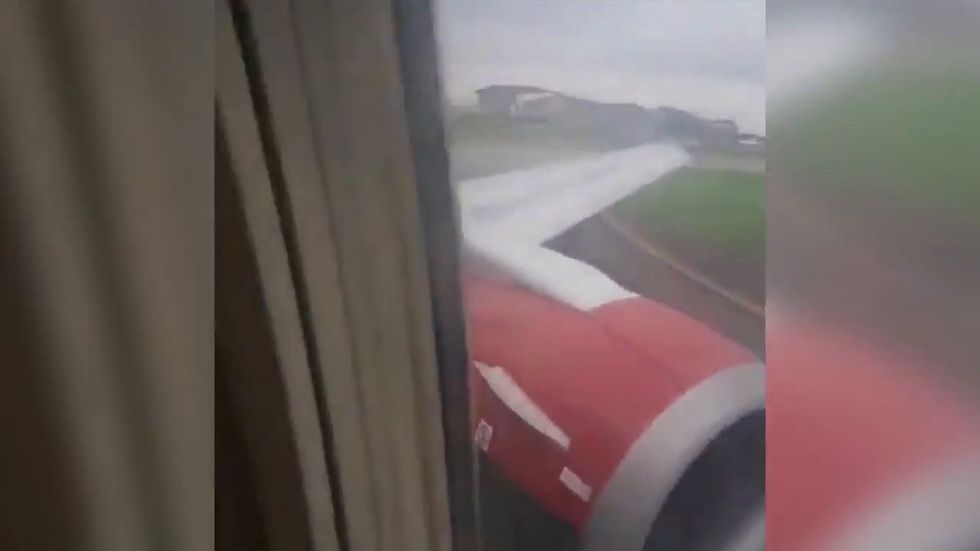 Man climbs onto wing of plane as it is about to take off