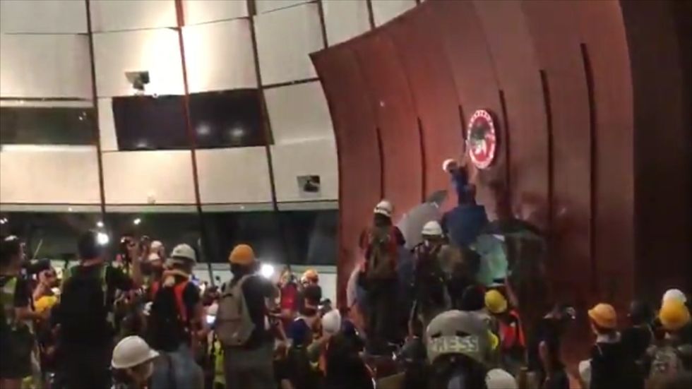 Thousands of protesters  swarm into legislative council and spray-paint walls 