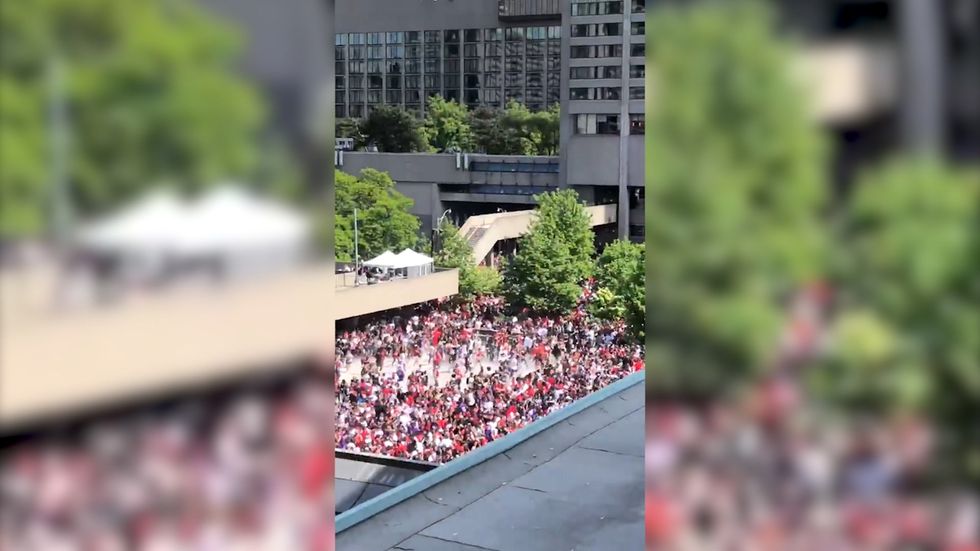 Fans run out of Nathan Phillips Square during the Raptors NBA Championship fan rally as gunshots are reported