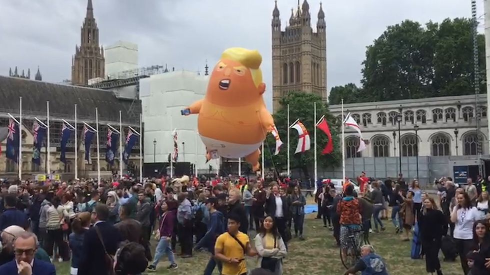 Donald Trump drives past giant inflatable baby blimp at parliament square protest