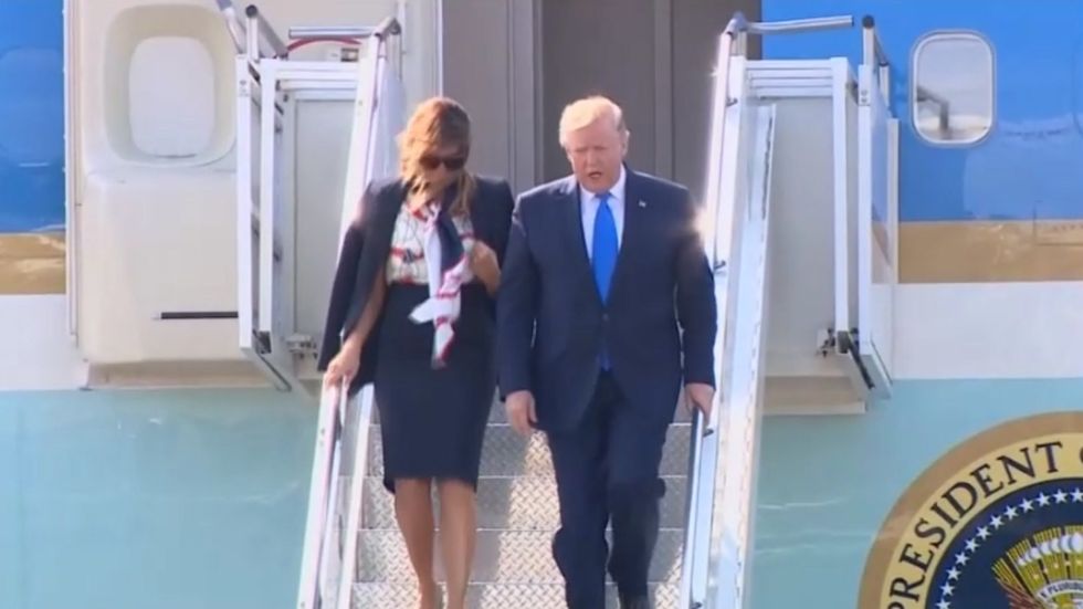 Donald Trump walks down stairs after landing at London Stansted Airport