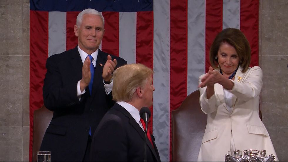 State of the Union: Nancy Pelosi stands and leans towards Donald Trump as she pointedly applauds him