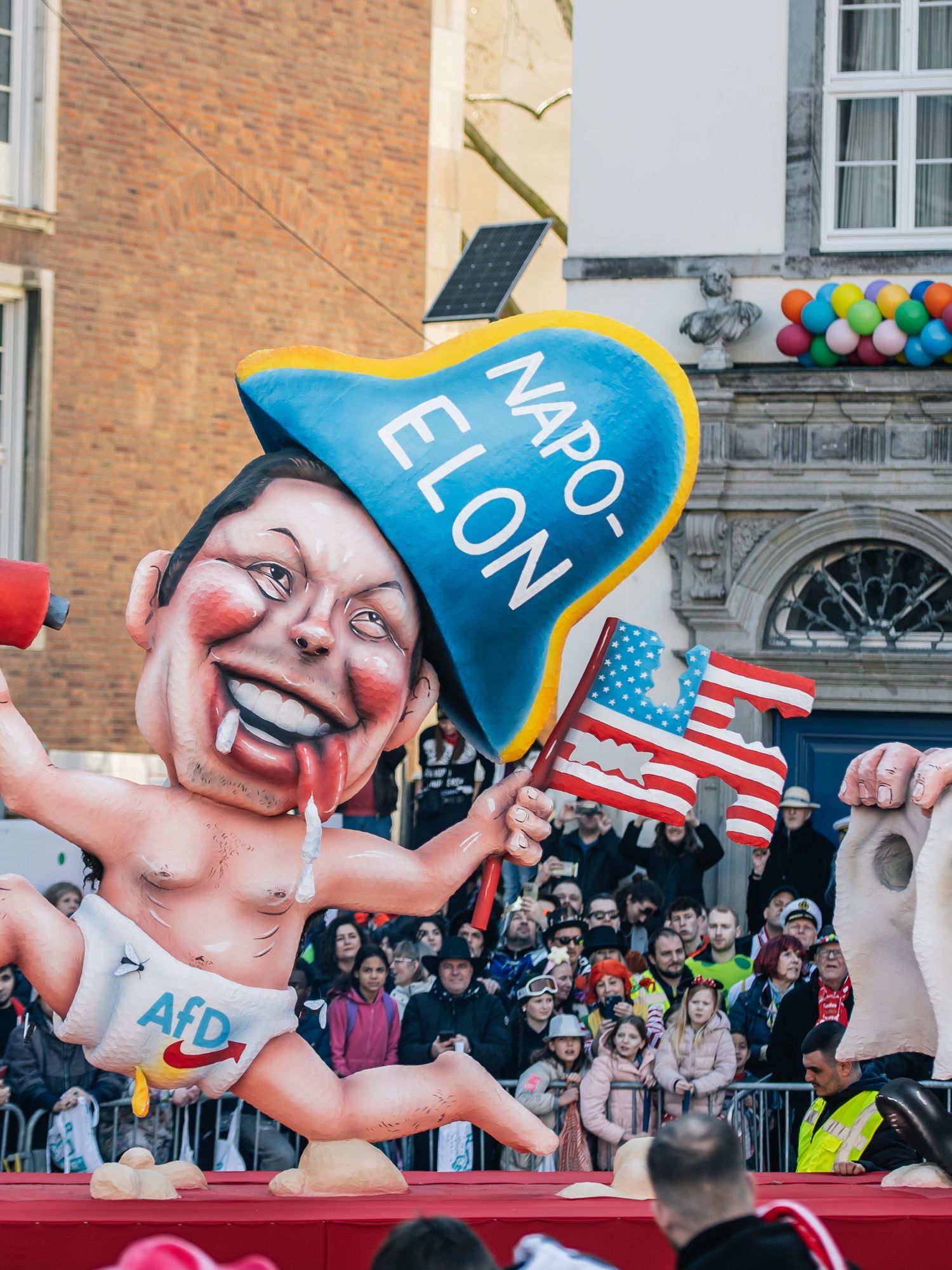 Elon Musk float depicted holding a swastika and a poo-filled X megaphone at German parade