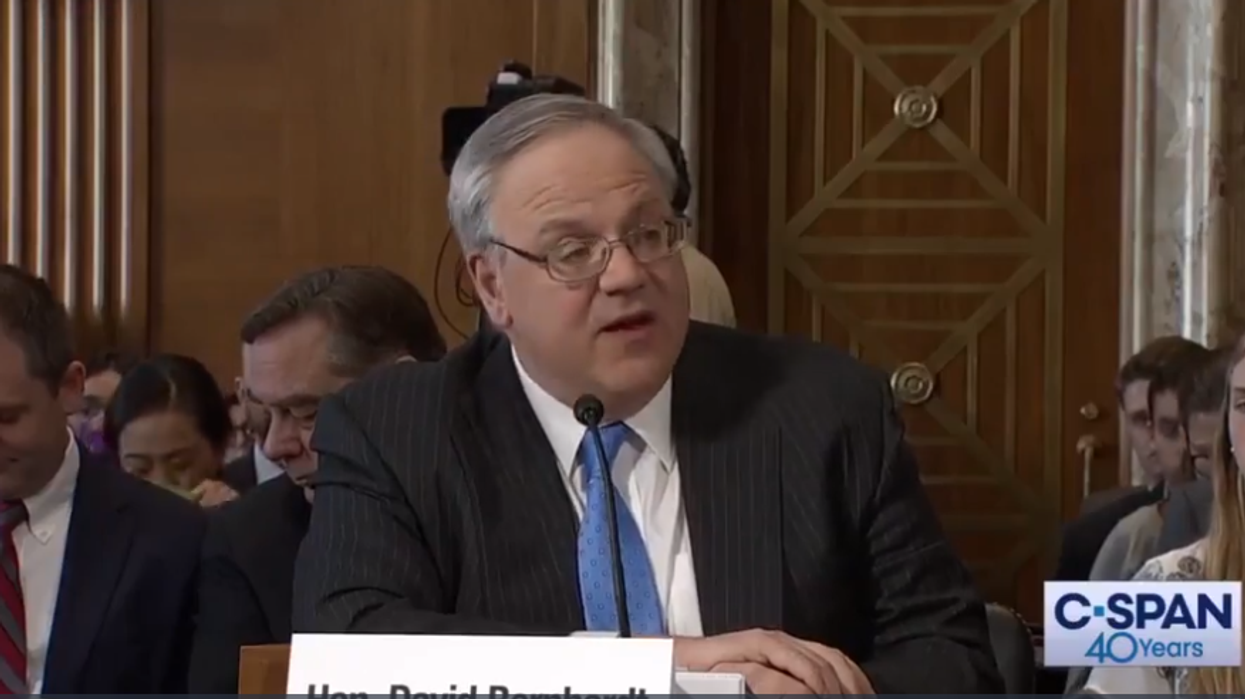 Trump appointee is mocked during his confirmation hearing by activist wearing a Creature from the Black Lagoon mask