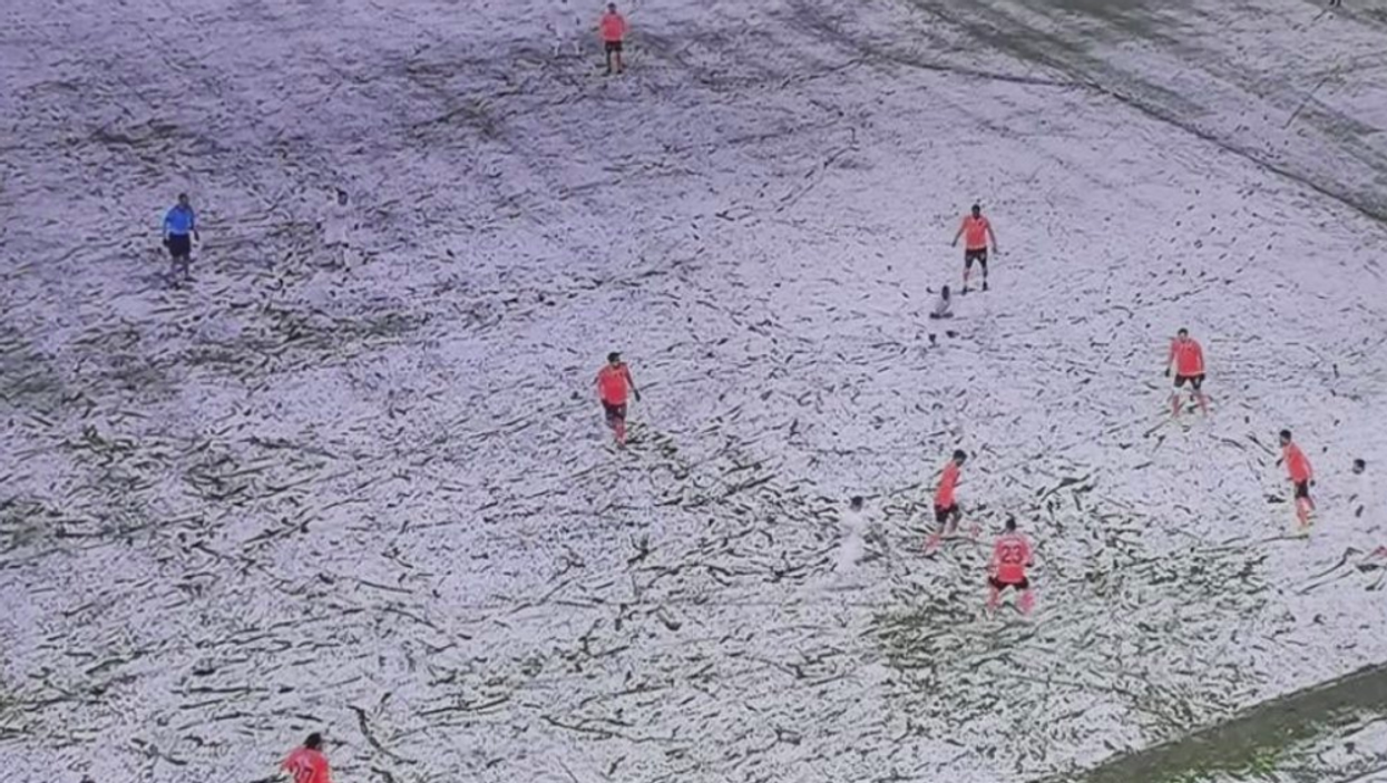 Can you guess how many footballers wearing white are in this picture of a snow-covered pitch?