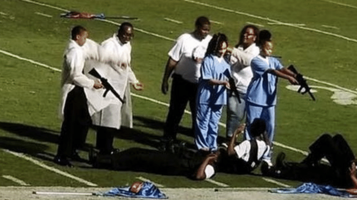 High school forced to apologise for half-time performance which featured students pointing guns at police