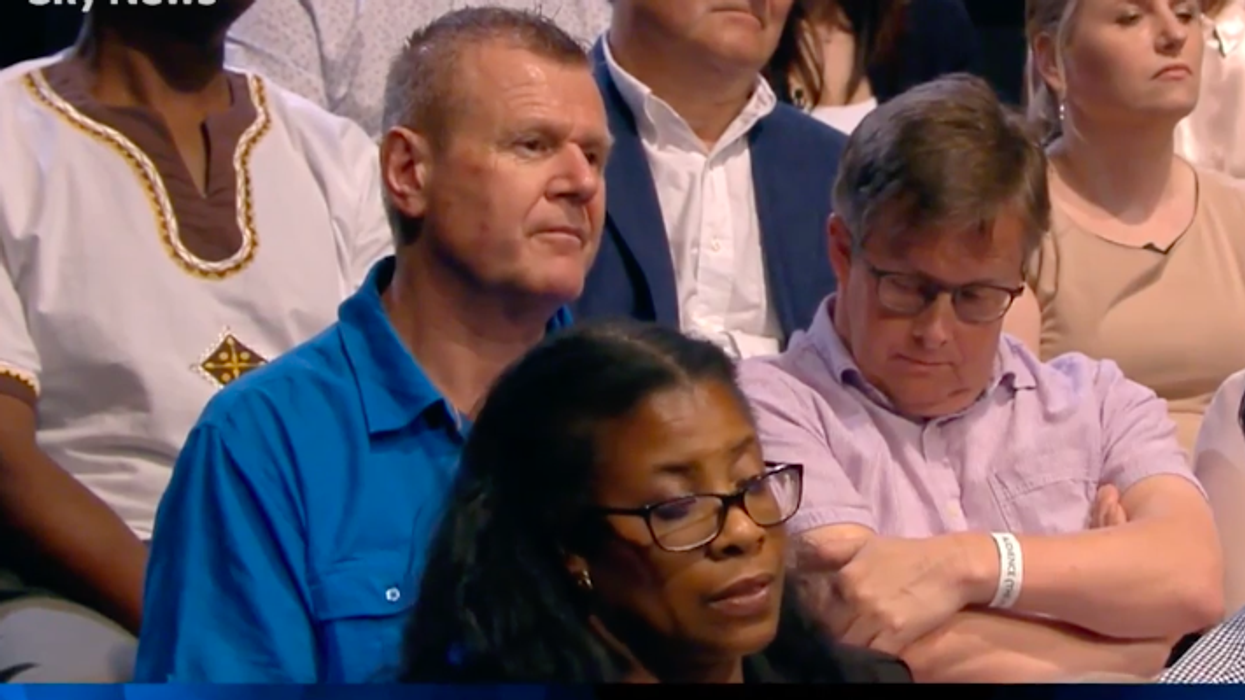 People think a man was mouthing b****cks at Theresa May as she claimed the Tories were putting more money into the NHS