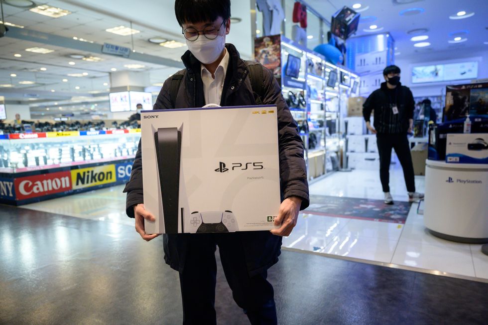 In a photo taken on November 12, 2020, a customer walks away after purchasing the new Sony Playstation PS5 in Seoul after Sony launched the new console in select markets around the world