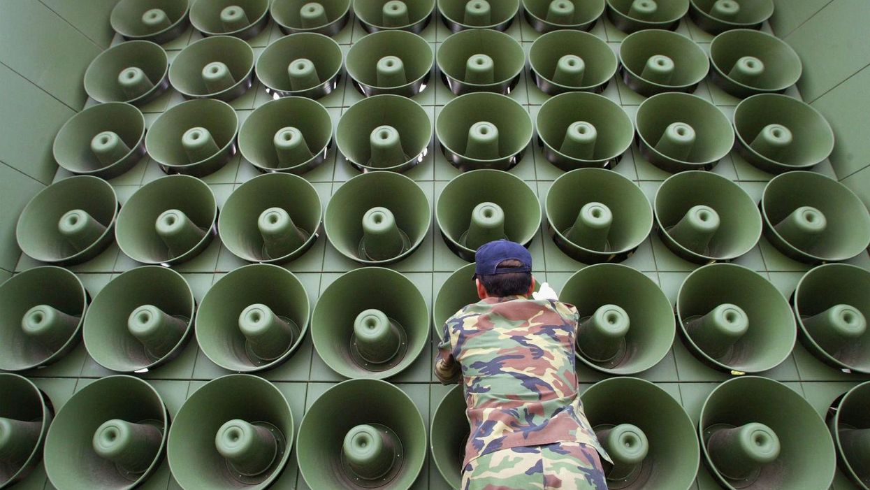 In this stock image, a South Korean soldier takes down a battery of propaganda loudspeakers on the border with North Korea on 16 June 2004 in Paju, South Korea.