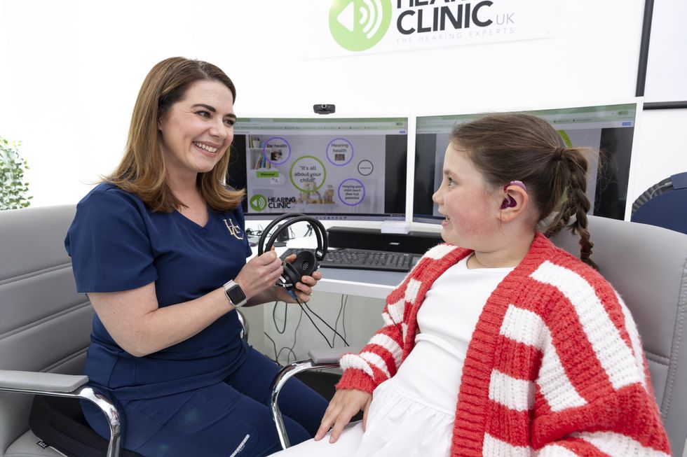 Iona Fagerson, 7, pictured with senior audiologist Dominique Stone at The Hearing Clinic UK's clinic in Milngavie