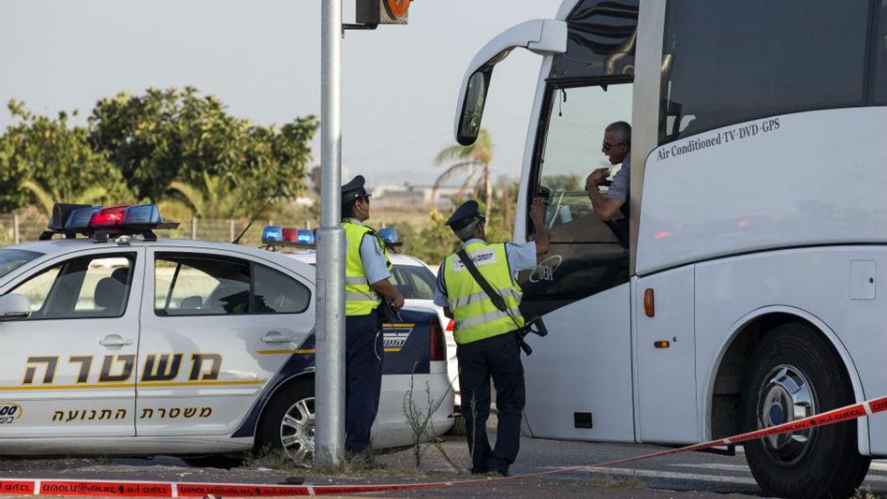 Israeli police officers speak to a bus driver at a checkpoint to the city of Qalansuwa