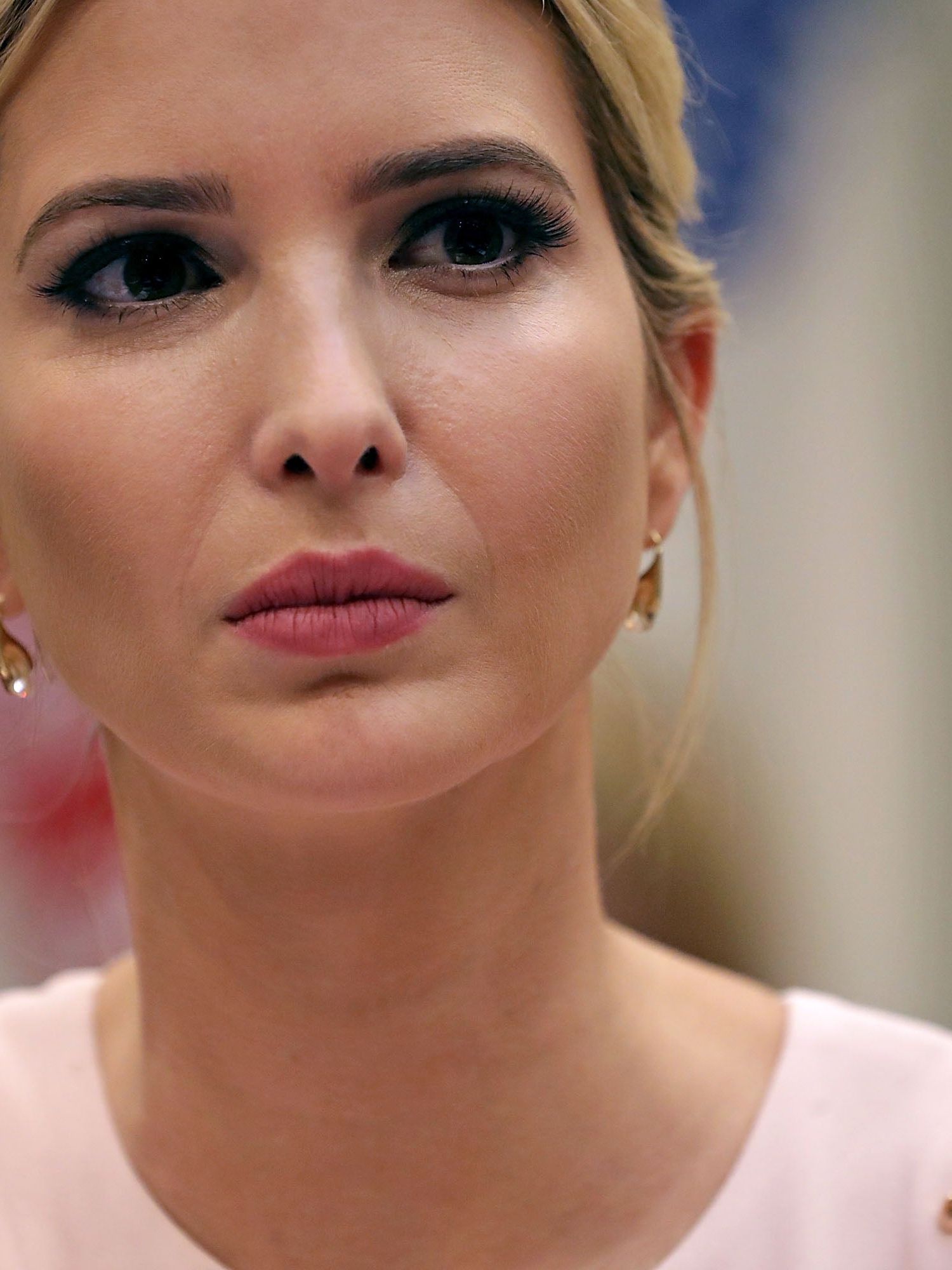Ivanka Trump, a white woman with short blonde hair and a white dress. She has a neutral expression on her face.