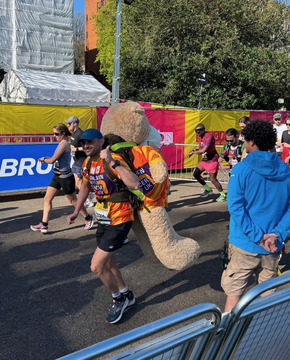 James Page gives a thumbs up as he runs the Brighton Marathon with a two-metre tall bear strapped to his back