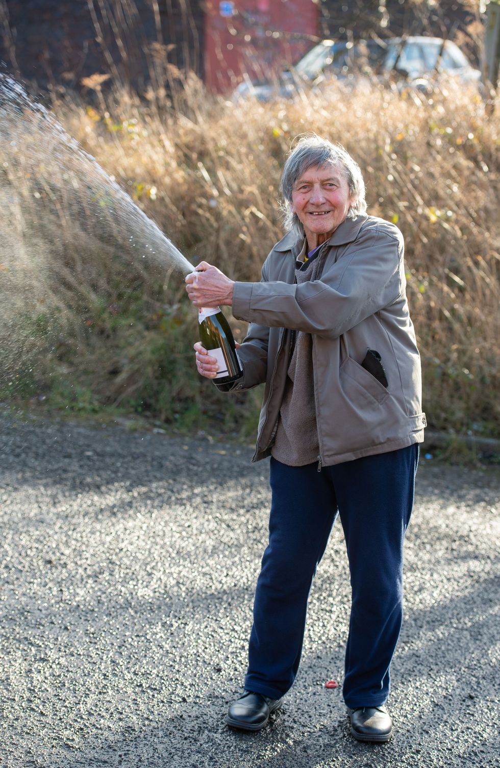 Janus "George" Wagonback opens a bottle of champagne