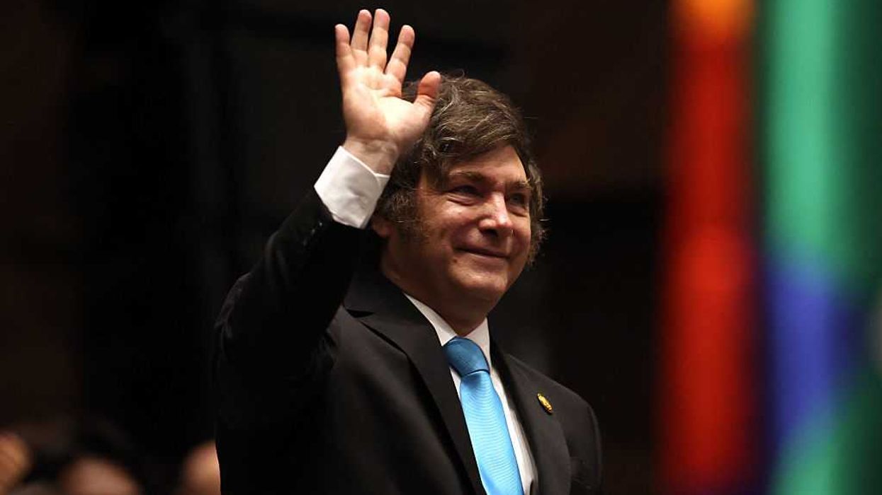 Javier Milei waves during the inauguration ceremony of Bolivia's President-elect Rodrigo Paz.