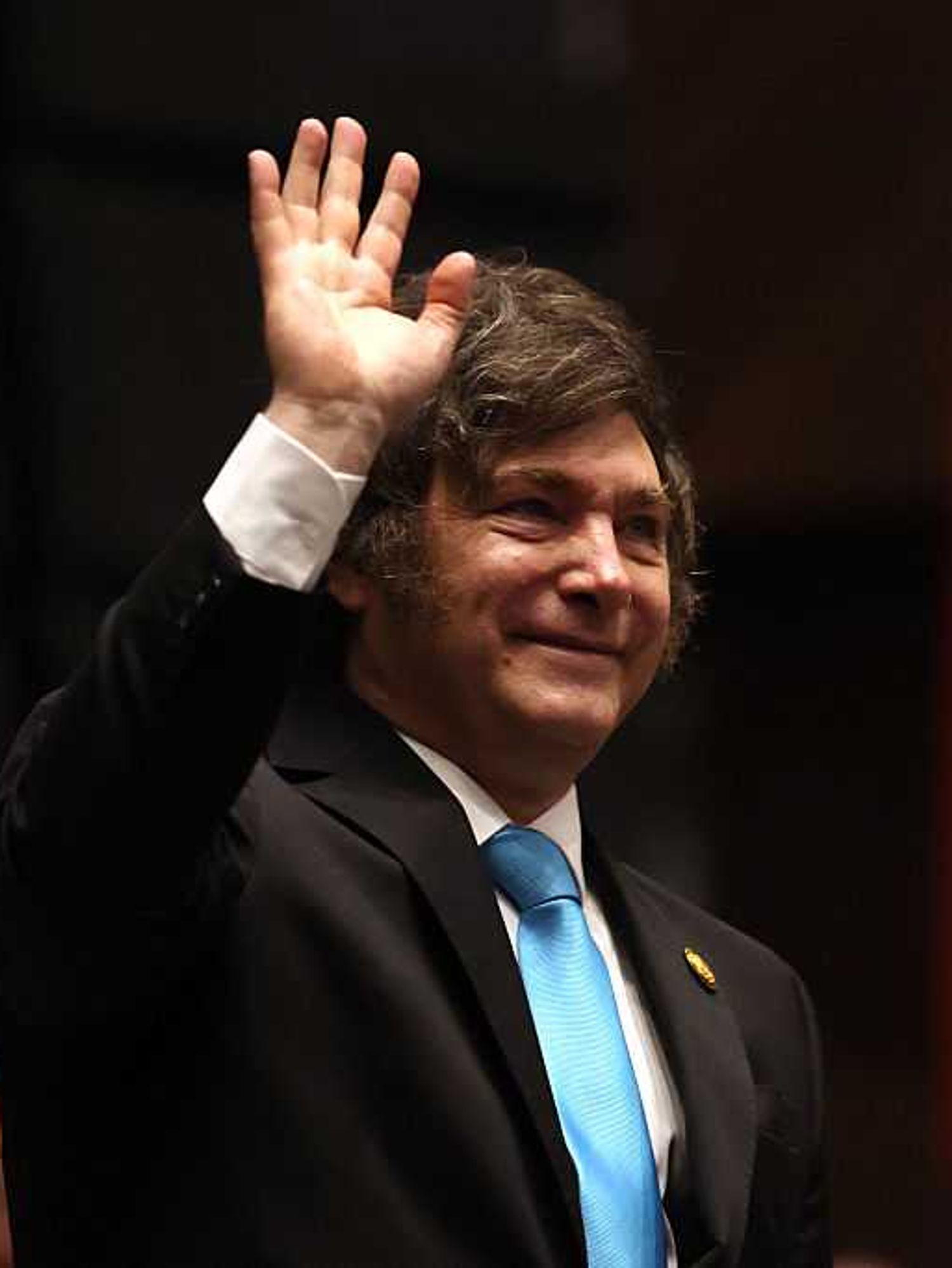 Javier Milei waves during the inauguration ceremony of Bolivia's President-elect Rodrigo Paz.